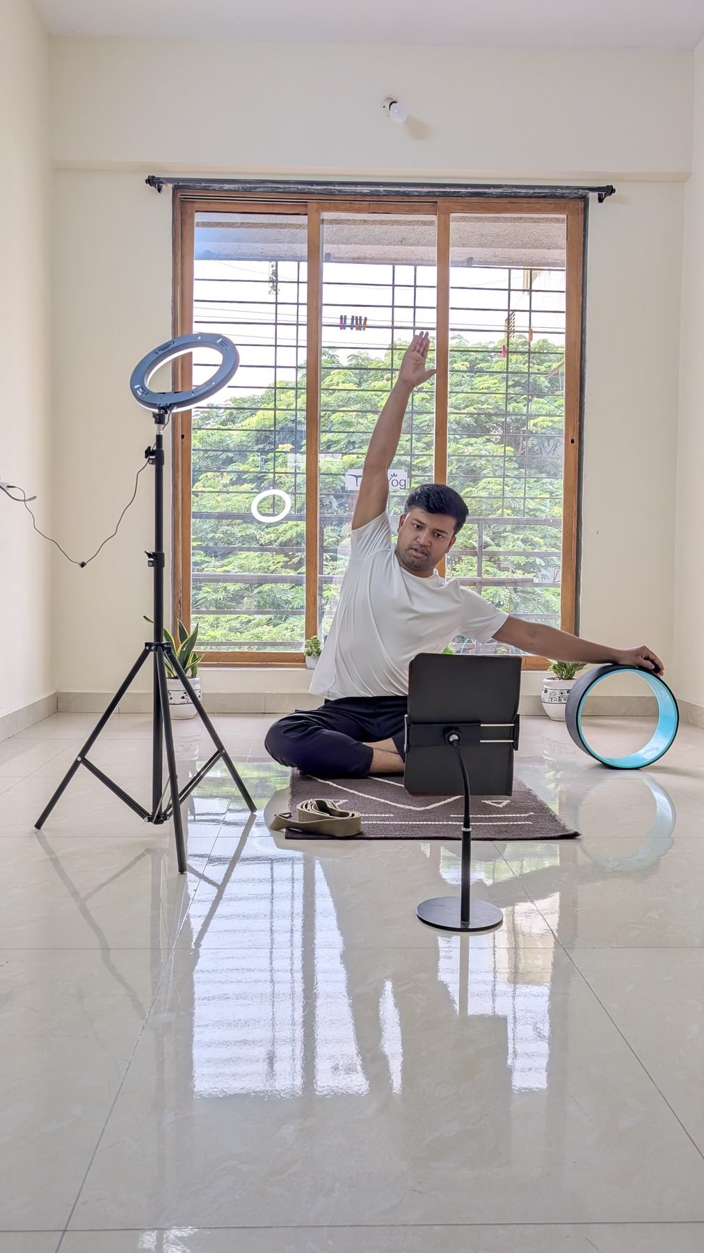 Yogi Gajendra demonstrating a gentle seated side stretch during a home practice session