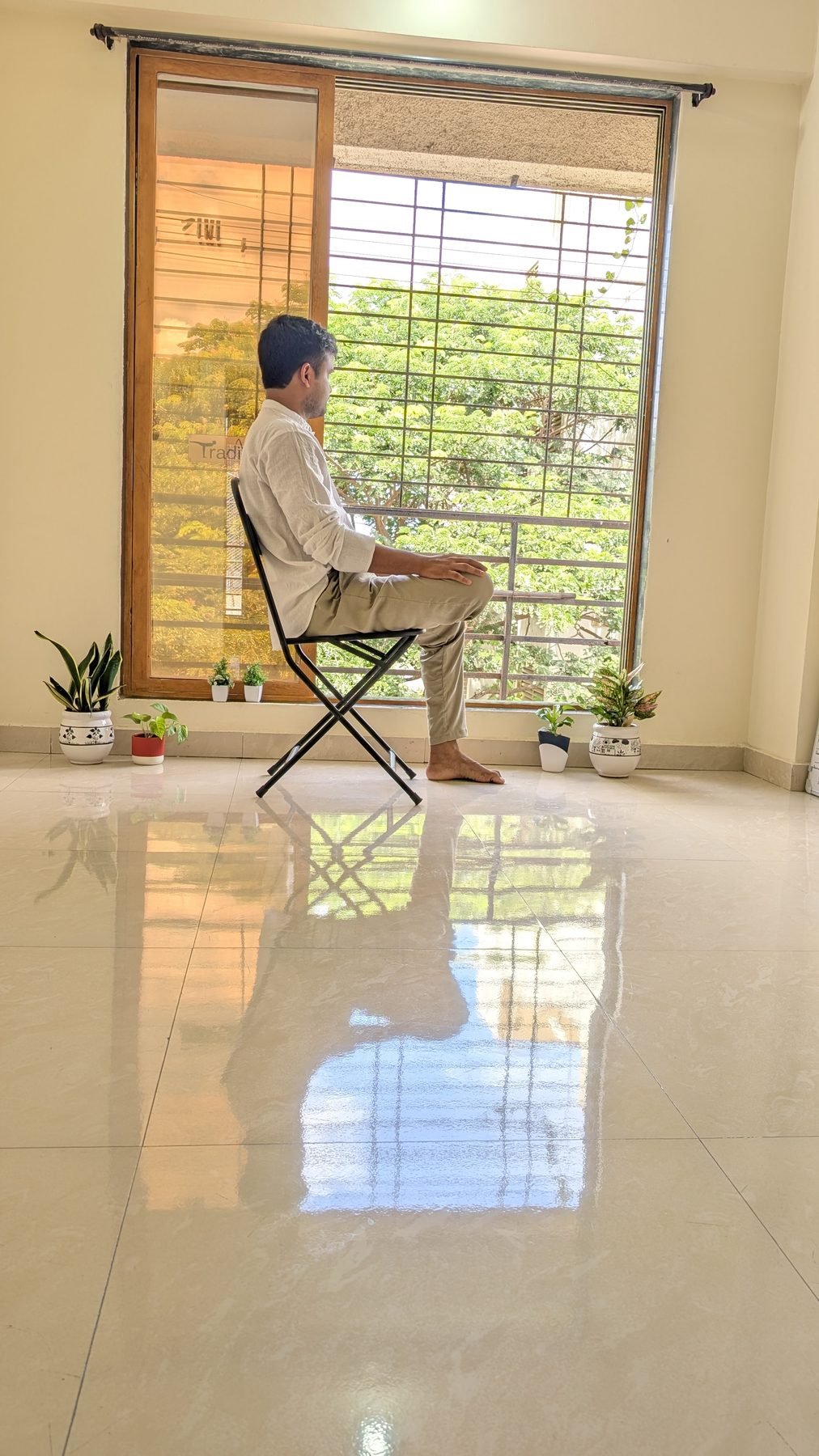 Yogi Gajendra sitting quietly by a window, in calm reflection between sessions
